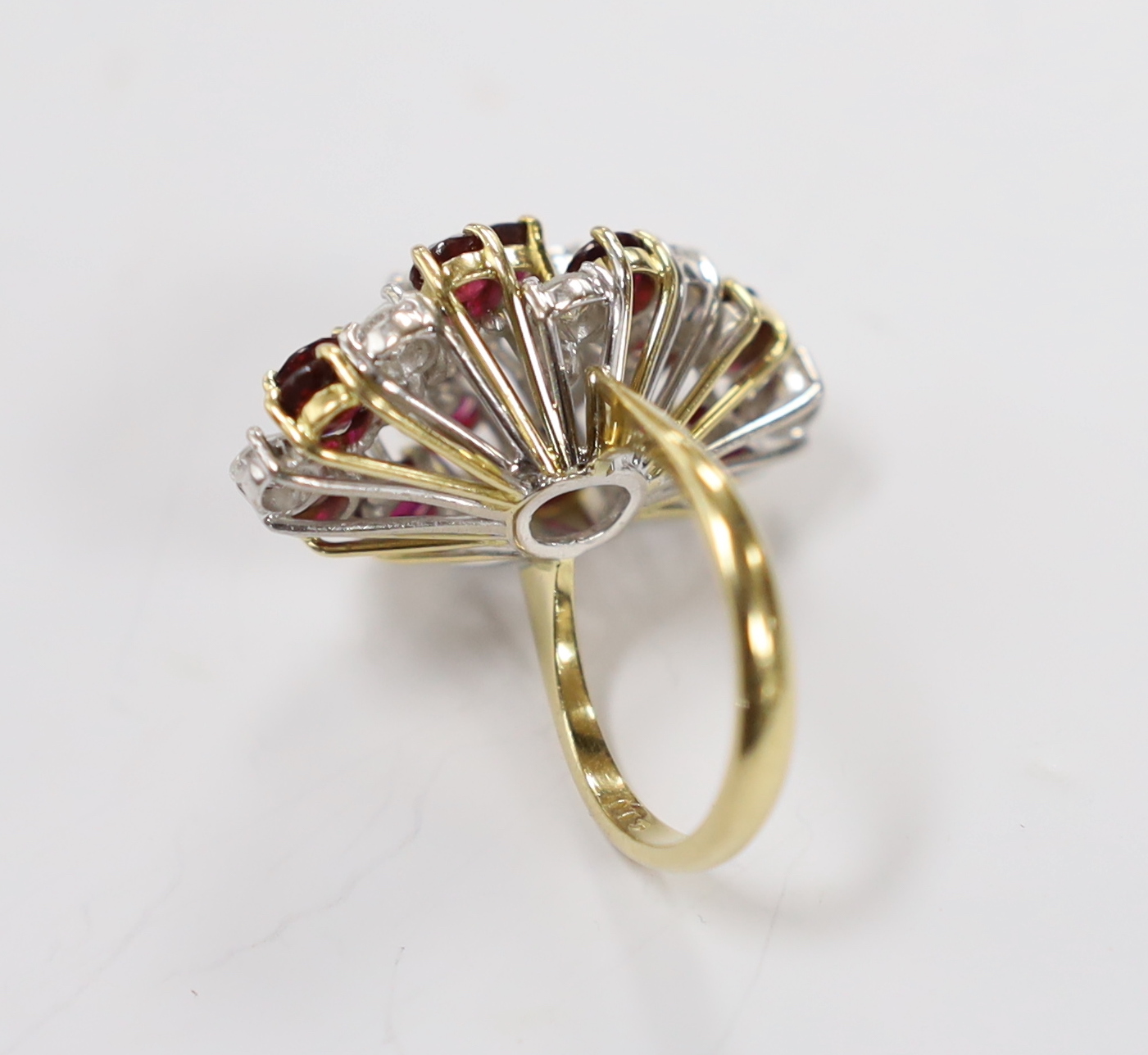 A modern yellow metal, ruby and diamond set oval cluster dress ring, size L/M, gross weight 11.4 grams.